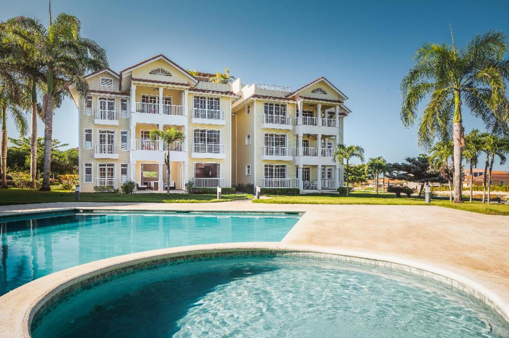 a large house with a swimming pool in front of it at Amazing Condos at Sosua Ocean Village in Sosúa