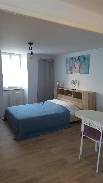 une chambre avec un grand lit et une table dans l'établissement Studios tout équipés, à Cosne-Cours-sur-Loire