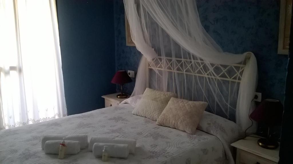 een slaapkamer met een wit bed met twee kaarsen erop bij 30A MONANTERRA Atlanterra Urbanización Mar de Plata in Zahara de los Atunes