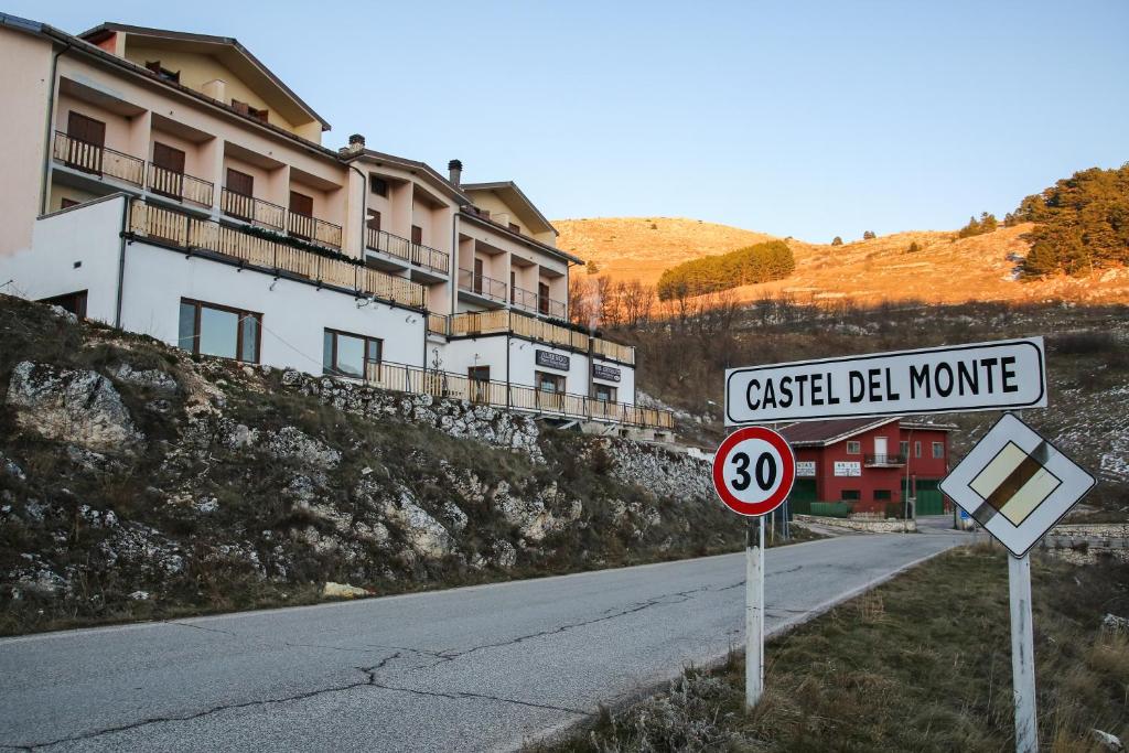 un cartello stradale sul lato di una strada di Albergo Parco Gran Sasso a Castel del Monte