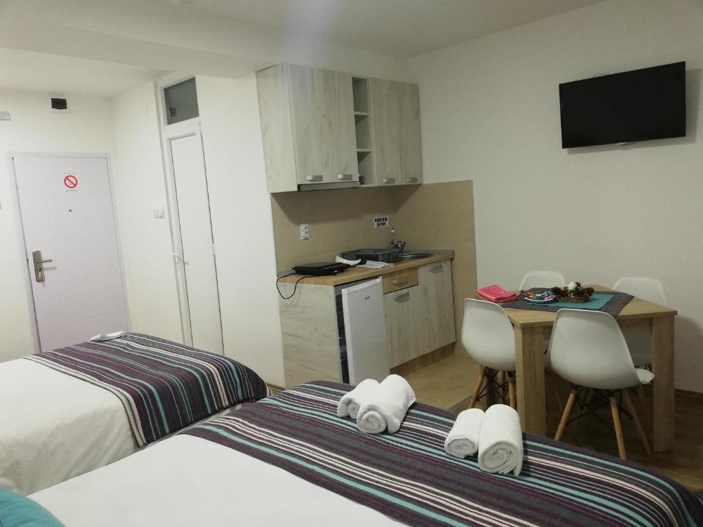 a room with two beds and a table and a kitchen at Vila Vrh in Crni Vrh