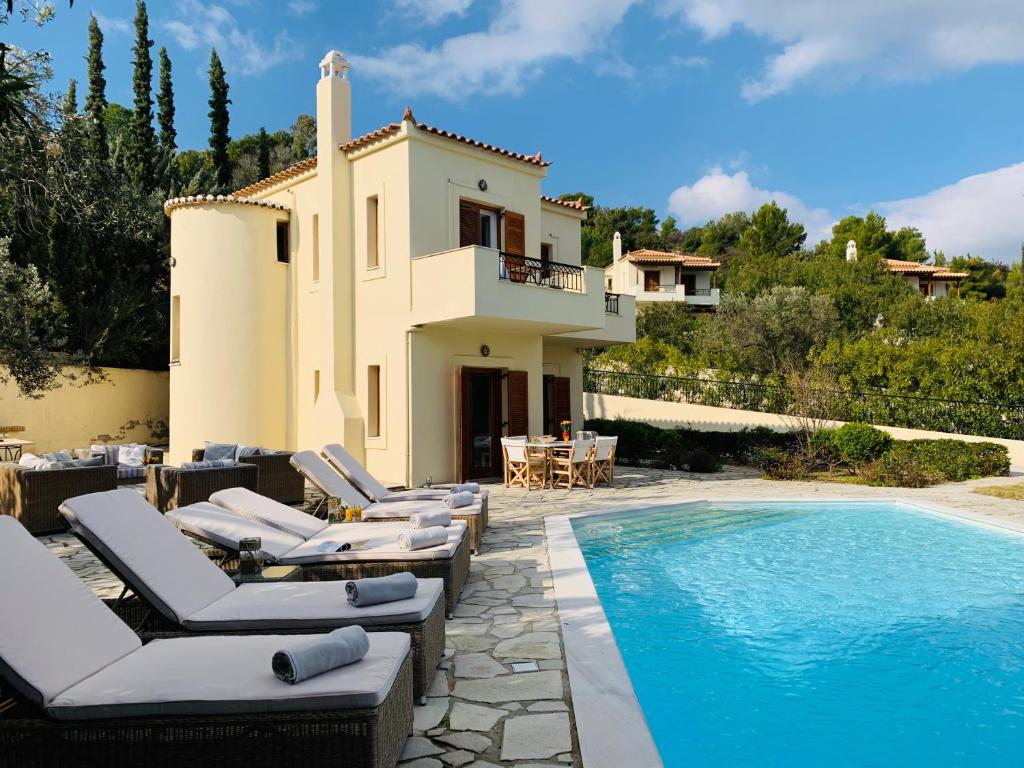 willa z basenem i leżakami w obiekcie Villa Serendipity Sea View w mieście Porto Heli