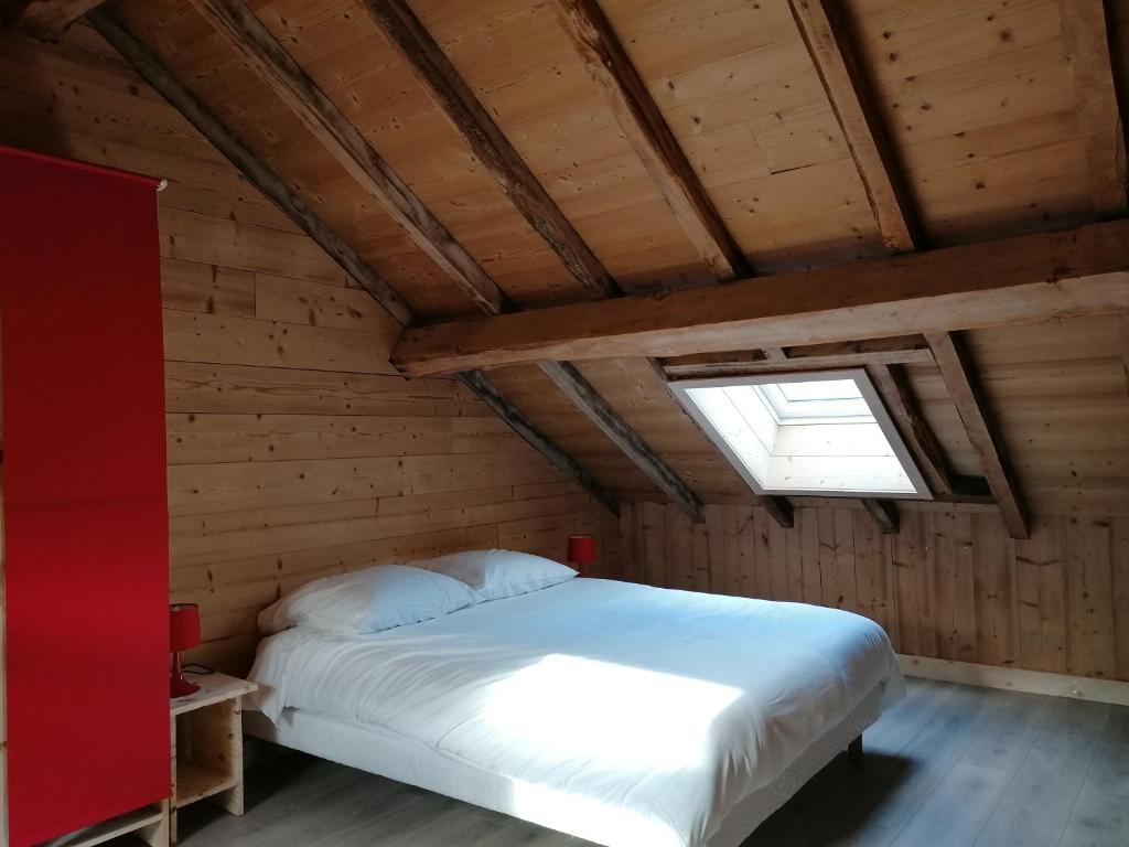 a bedroom with a bed in a wooden room at La ferme de lucien in Sallenôves