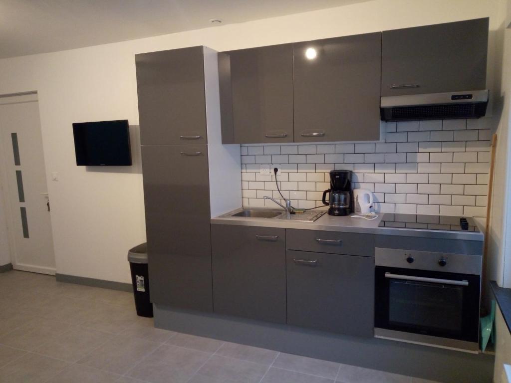 a kitchen with gray cabinets and a microwave at Merlimont Plage - Paola in Merlimont