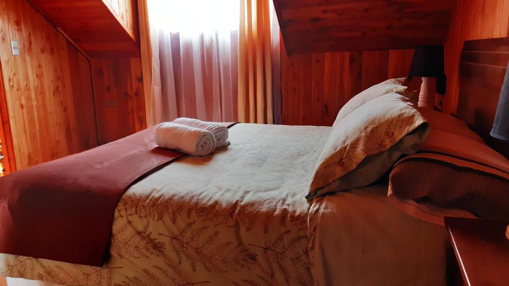 een slaapkamer met een bed met een handdoek erop bij Casa Tregül B&B in Villarrica