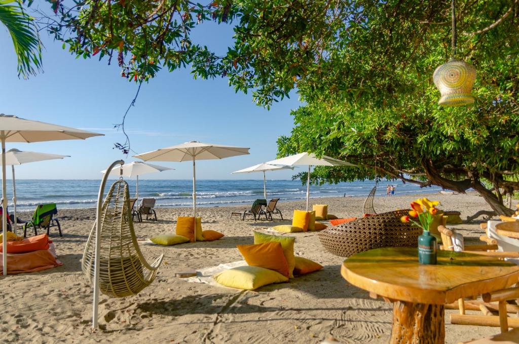 una playa con sillas, mesas y sombrillas en LA DOLCE VITA - on the Beach - Samara, en Sámara