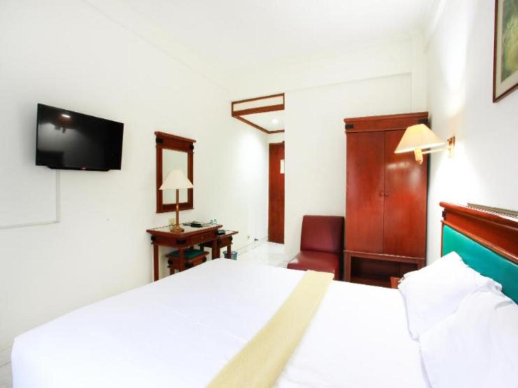 Postel nebo postele na pokoji v ubytování Puri Jaya Hotel
