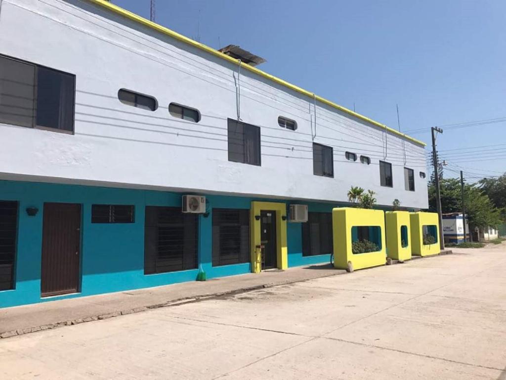 een gebouw met gele en blauwe deuren en ramen bij Hotel Tamuin in Antiguo Tamuín