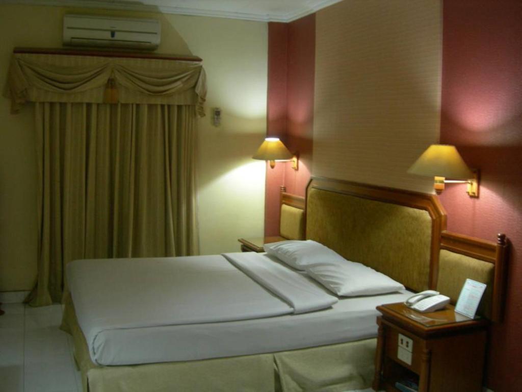 Postel nebo postele na pokoji v ubytování Puri Jaya Hotel