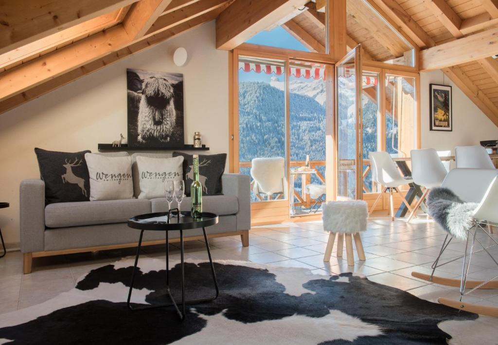 a living room with a couch and a table at Chalet Rose Penthouse in Wengen