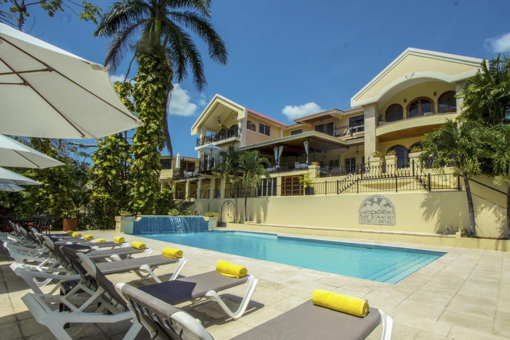 a villa with a swimming pool and lounge chairs at San Ignacio Resort Hotel in San Ignacio