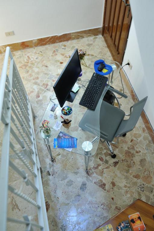 laptopa siedzącego na szklanym stole w obiekcie Terra Sinus Holiday House w mieście Terrasini