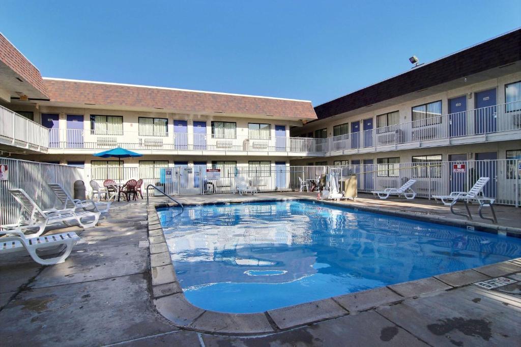 uma piscina em frente a um edifício com um hotel em Motel 6-Lubbock, TX em Lubbock