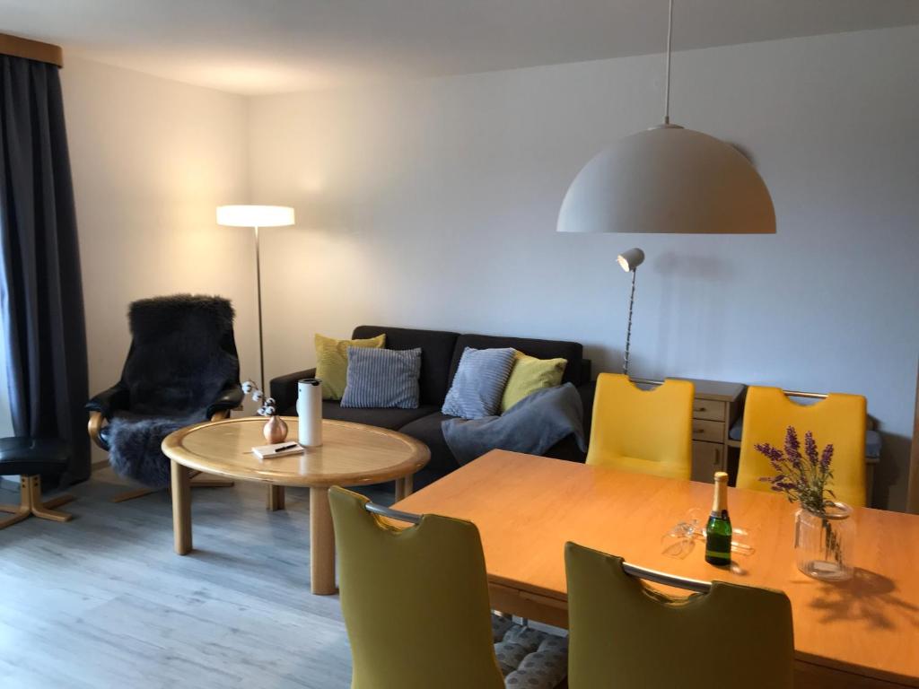 een woonkamer met een bank en een tafel en stoelen bij Wohnung an der Skiwiese - Boxspring - Balkon - 2 Smart TV - Carport in Braunlage