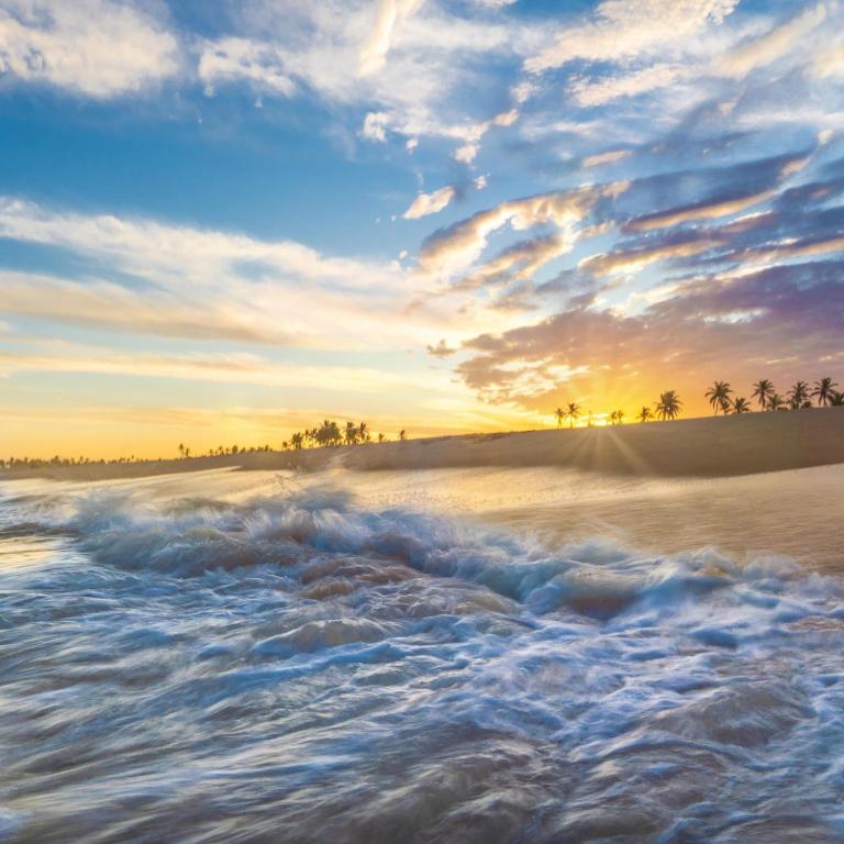 una foto de una playa al atardecer en VILLAGE DAS ÁGUAS, en Imbassai