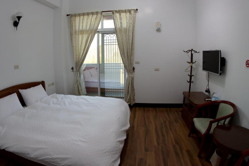 a bedroom with a white bed and a window at Cuiti B&amp;B in Fenqihu