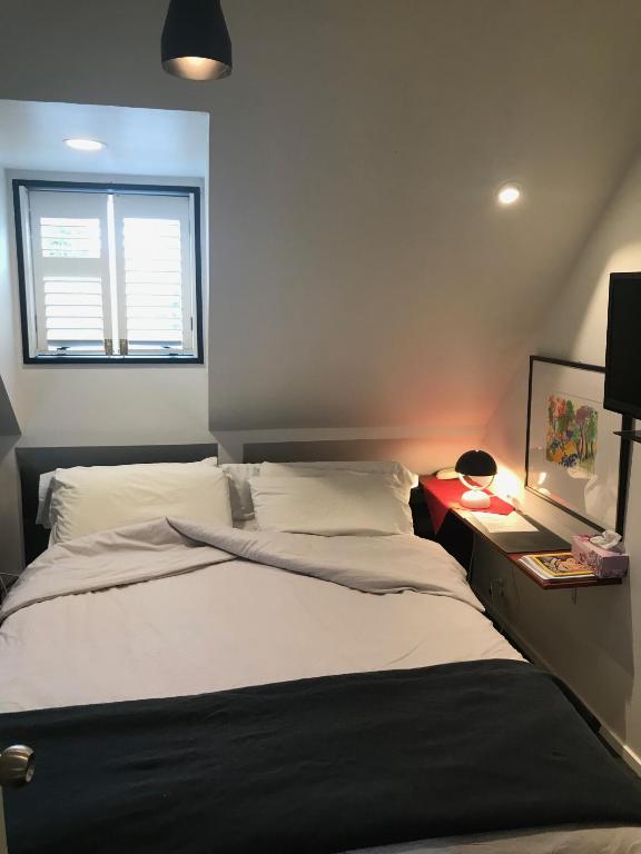 a bedroom with a large bed with a window at Pryor Haven Chalet Green Retreat in a Lovely Place in Christchurch