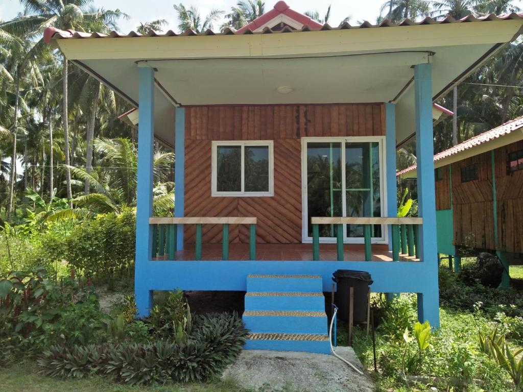 a tiny house with a porch and blue trim at Happy Days Resort in Ko Mak