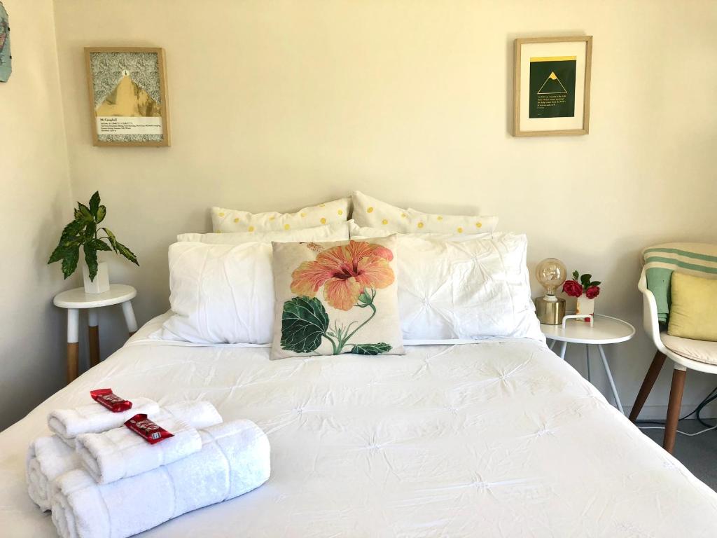 una camera da letto con un letto bianco e asciugamani di Sunny, Serene Studio @ Motueka a Motueka