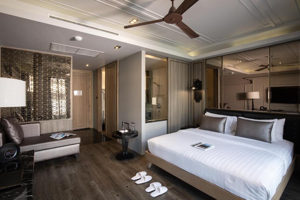 1 dormitorio con 1 cama blanca grande y 1 sofá en De Chai the Deco Chiang Mai - SHA Plus en Chiang Mai