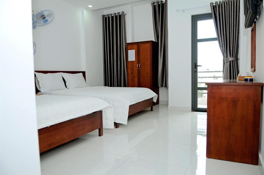 1 dormitorio con 2 camas y ventana en Anh Thư Hotel en Vung Tau