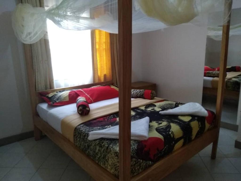 two bunk beds in a room with a window at KERESI BUDGET BLOCK at PENIEL in Entebbe