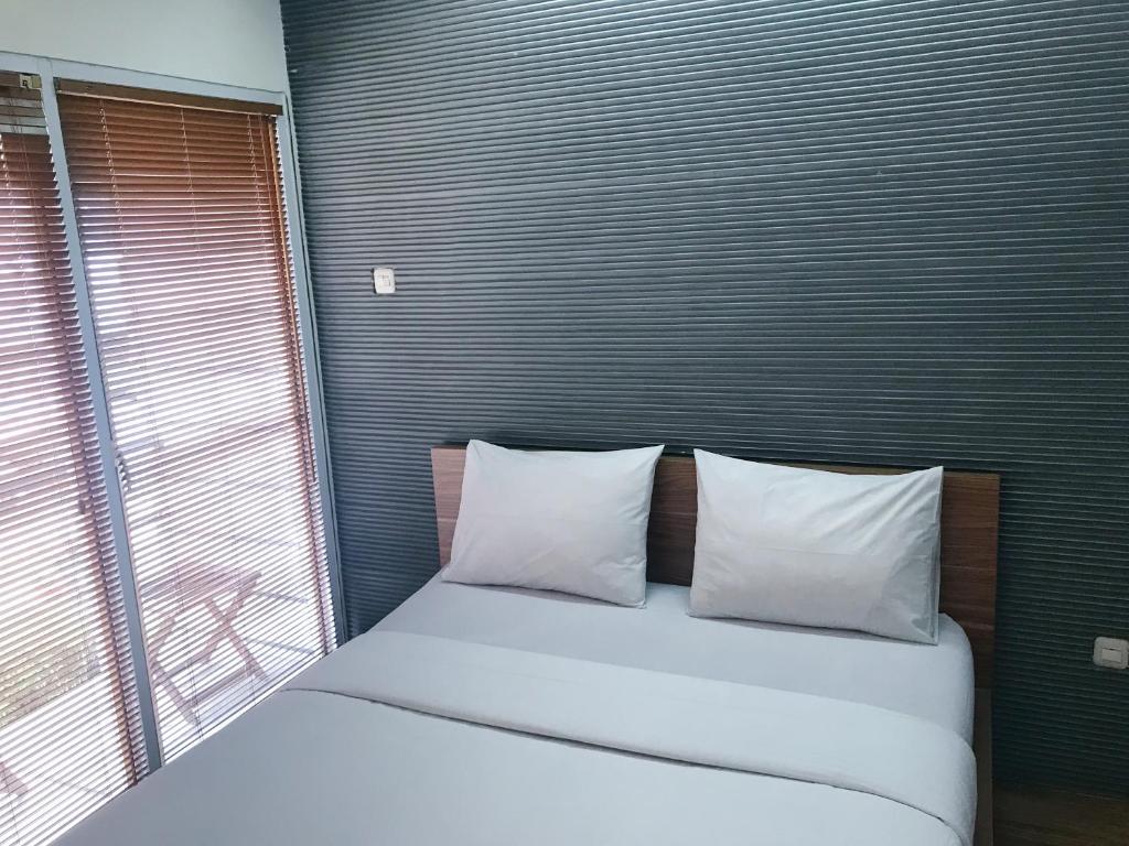 een slaapkamer met een bed met 2 kussens en een raam bij FLAT06 cipete in Jakarta