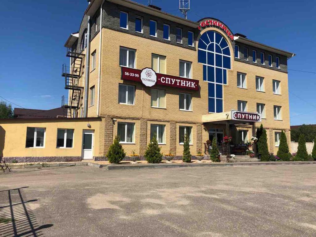 ein großes Backsteingebäude mit einem Schild darauf in der Unterkunft Mini-hotel Sputnik in Iwanowo