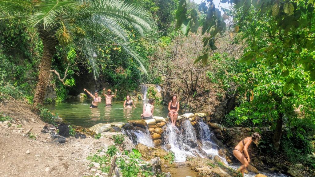 a group of people in the water at a waterfall at TRIBE AQUA a nature retreat above Neer waterfall in Rishīkesh