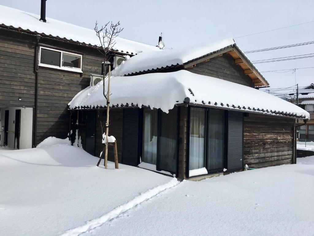 Una casa con nieve en el techo. en B&B Neagari, en Nomi