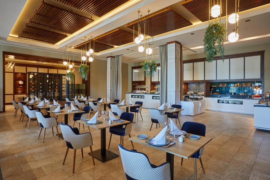 a restaurant with tables and chairs and a bar at Secrets Lanzarote Resort & Spa - Adults Only (+18) in Puerto Calero