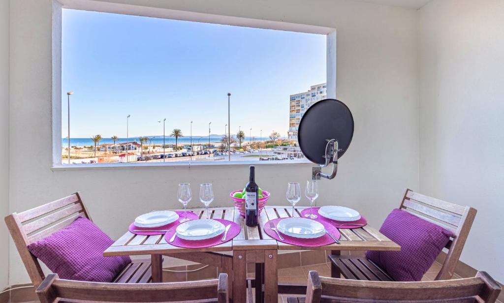 uma mesa de jantar com cadeiras e uma grande janela em Apart-rent Apartment Cristall Mar 2º 0058 em Empuriabrava