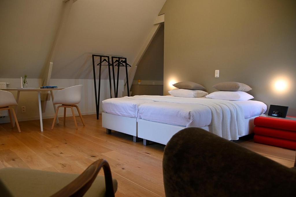 1 dormitorio con 1 cama grande con sábanas y almohadas blancas en B&B Korsele 59, en Horebeke