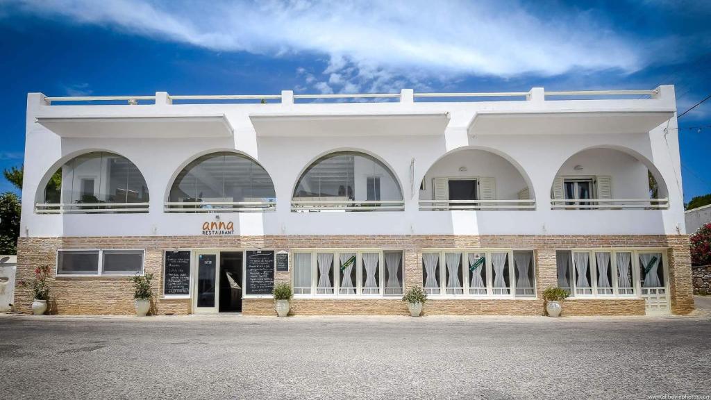 a white building with arches and windows on it at Hotel Ivi in Drios