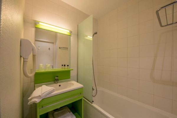 a bathroom with a sink and a mirror and a tub at Résidence Villemanzy in Lyon