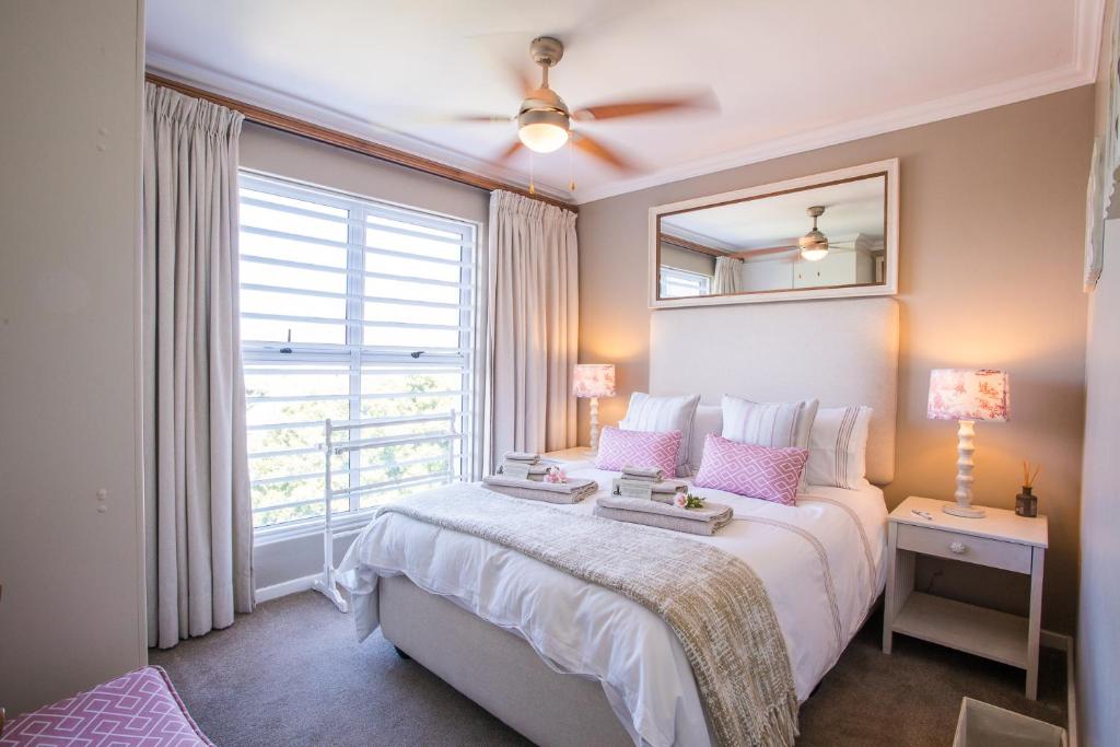 Un dormitorio con una cama grande y una ventana en dk villas 1 Harbour View Hout Bay, en Hout Bay