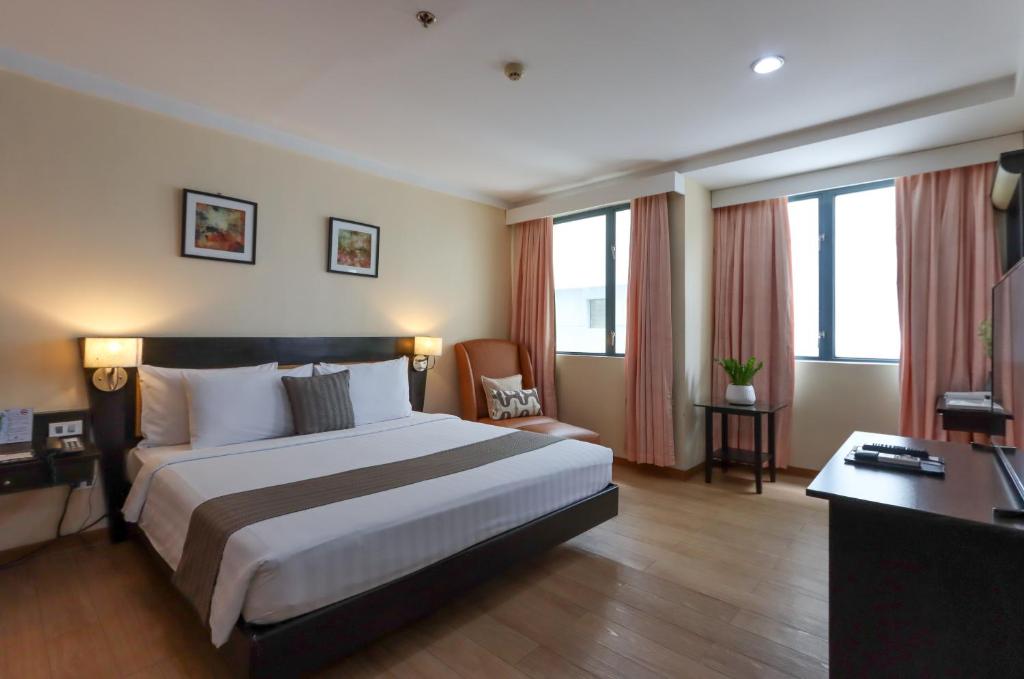 una camera d'albergo con un letto grande e una scrivania di Technopark Hotel a Santa Rosa