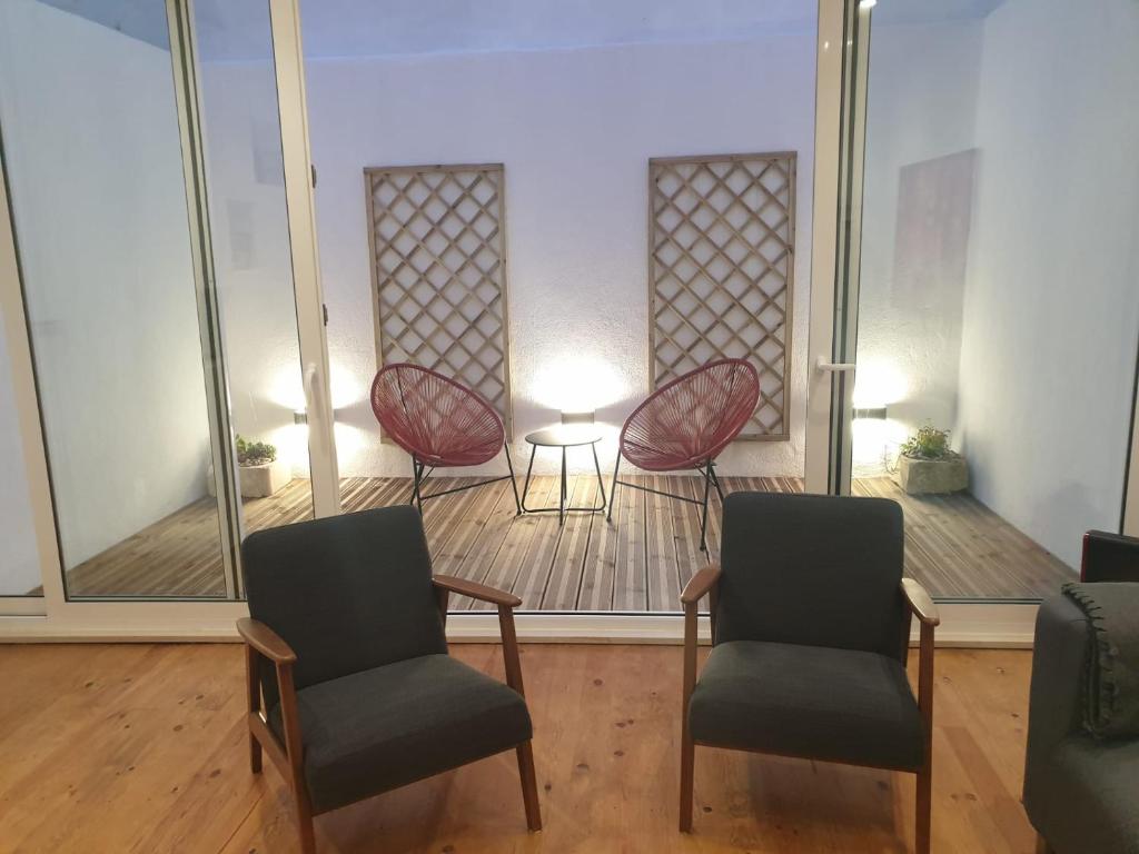 リスボンにあるステイ ホーム リスボンの椅子2脚とテーブル付きの待合室
