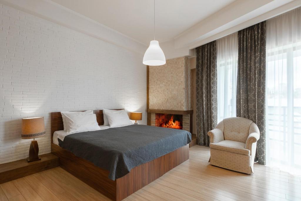 a bedroom with a bed and a fireplace at Hotel Libretto in Tbilisi City