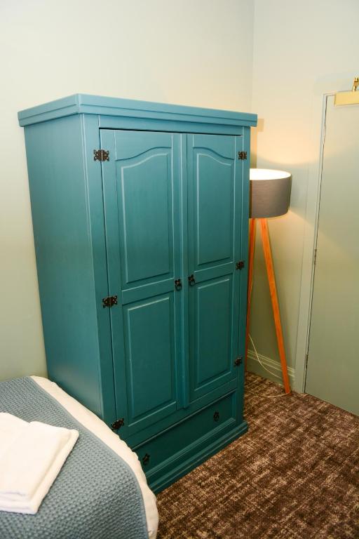 a blue cabinet in a room with a bed at Plough Inn in Morpeth