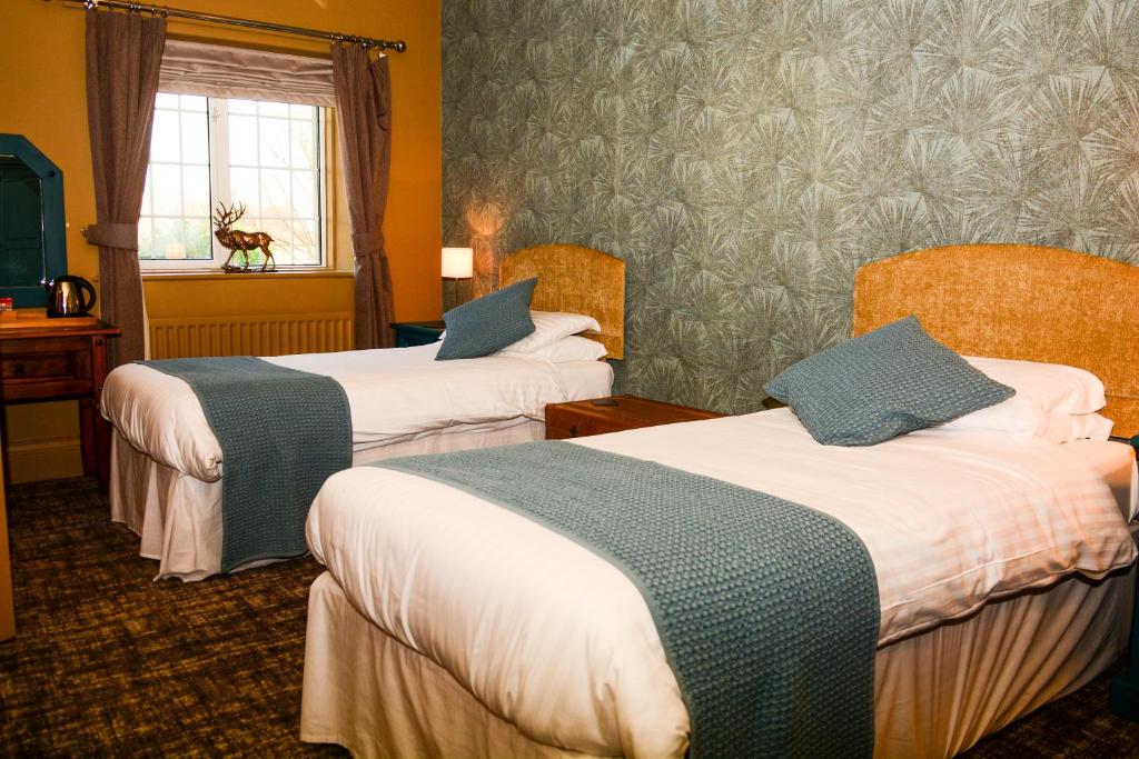 a hotel room with two beds and a window at Plough Inn in Morpeth