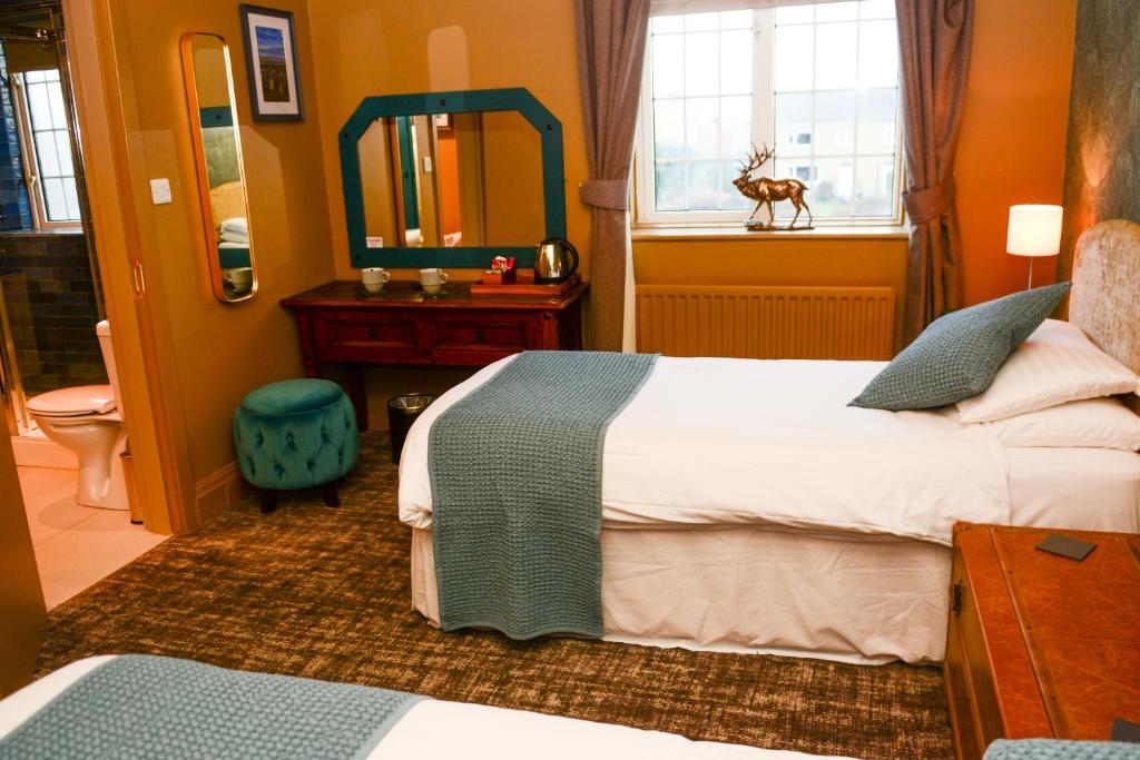 a hotel room with a bed and a mirror at Plough Inn in Morpeth