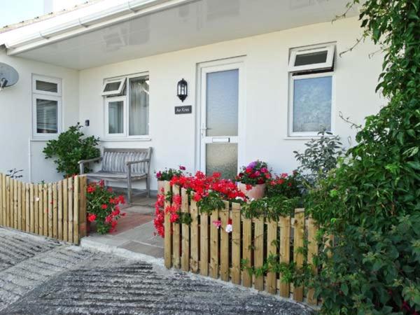 a house with a fence and flowers in front of it at An Kres in Mevagissey