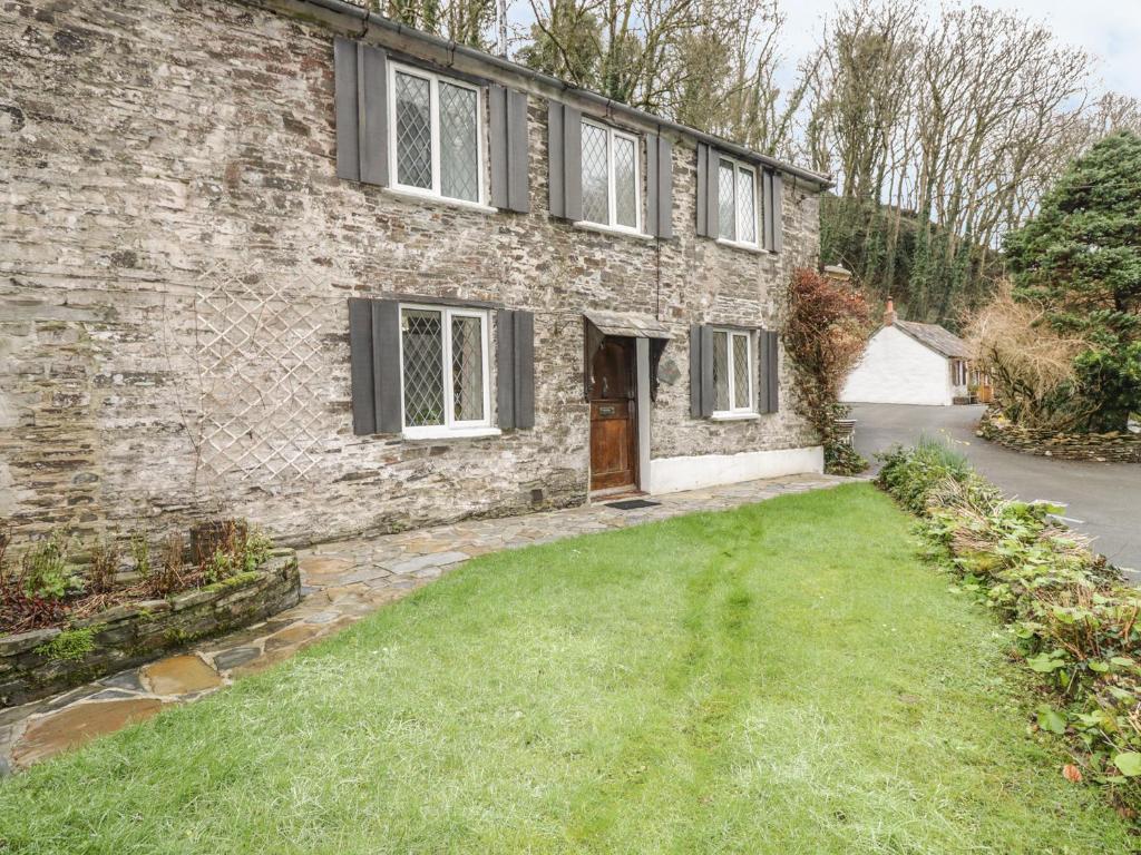 a brick house with a grass yard in front of it at Miller's House in Tintagel