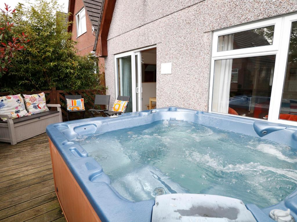 a jacuzzi tub in the backyard of a house at Dartmoor Valley Lodge in Gunnislake