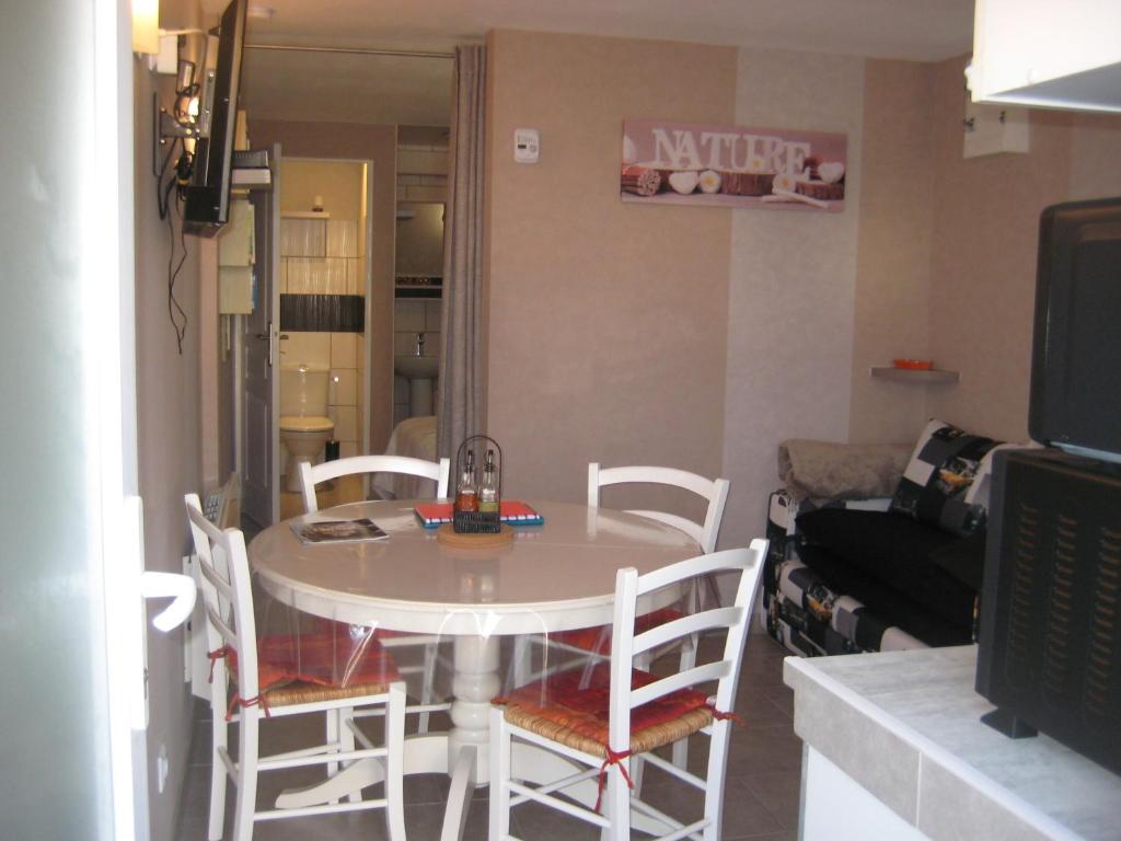 a table and chairs in a living room with a television at jujuouragan in Saint Die
