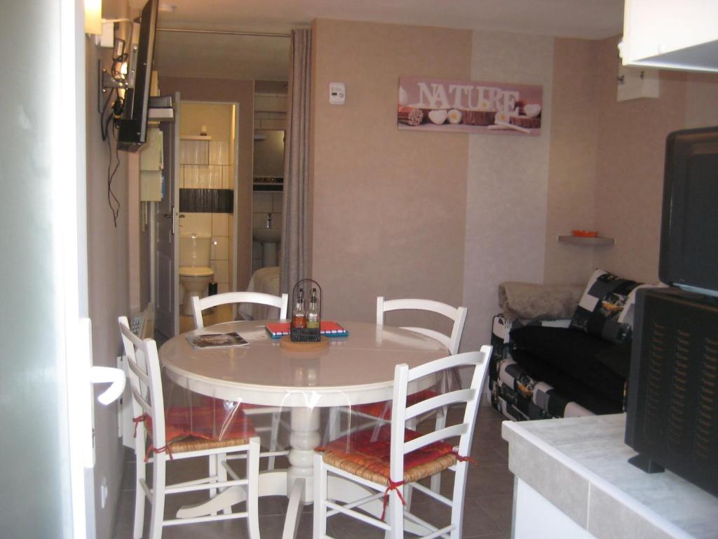 una mesa y sillas en una sala de estar con TV en jujuouragan, en Saint-Dié-des-Vosges