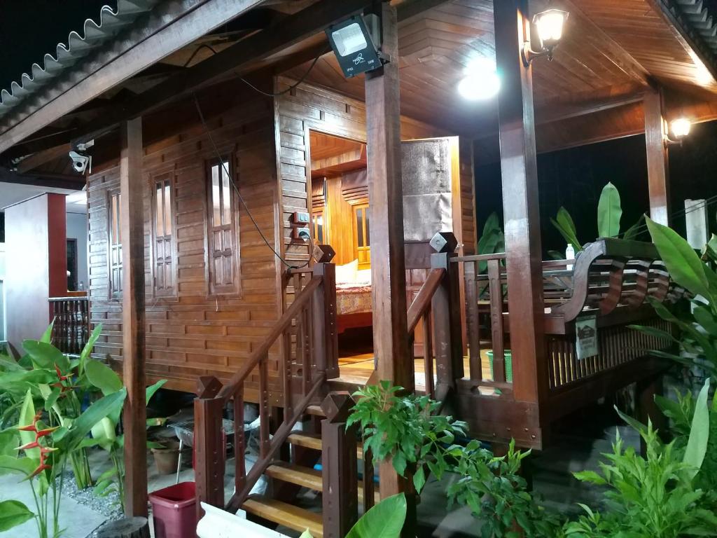 uma casa de madeira com uma escada que leva até ela em บ้านทะเลอิ่มเอม Bann Talay Im eimm em Ban Pak Khlong Phe