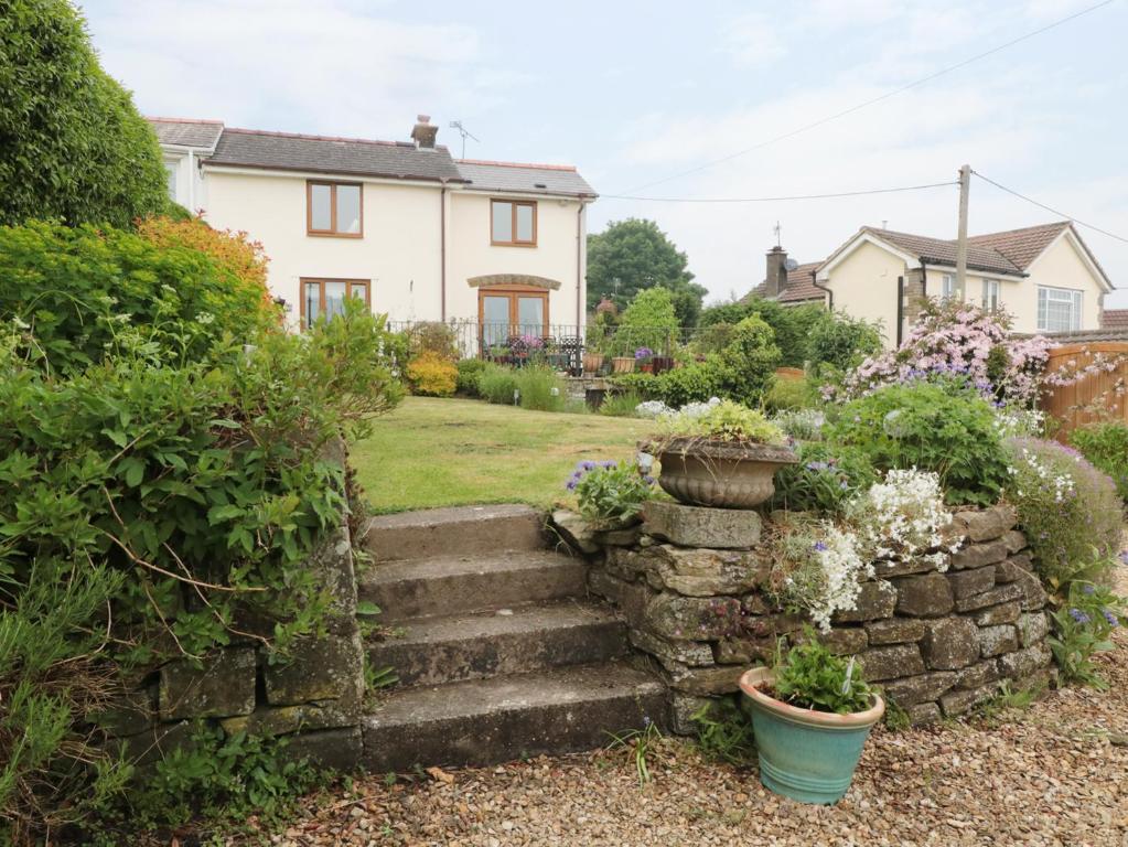 a garden with a stone staircase in front of a house at Lynton House in Drybrook