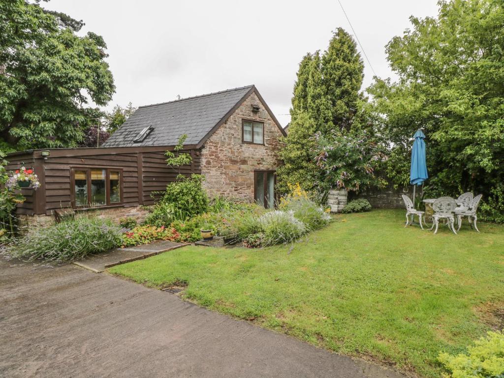 una casa con un patio con una casa en Pembridge Cottage, en Llanrothal